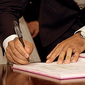 a man holding a pen signing document